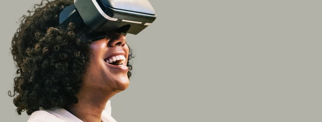 A woman wears a virtual reality headset, she's looking up and smiling